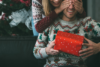 Tip na vianočný darček pre neho - žena obdarúva muža, obaja majú oblečené vianočné svetre