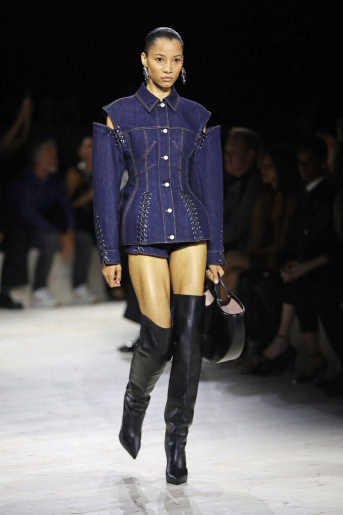 Módne topánky jar-leto 2024 – modelka v džínsovom outfite a vysokých čiernych čižmách, Alexander McQueen